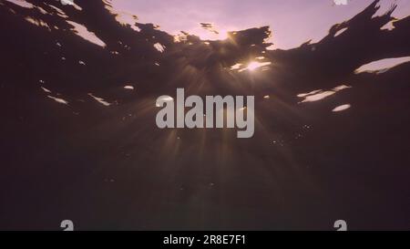 Evening sunlight creates beautiful veil, consisting of sunlight at sunset. Underwater ocean waves oscillate and flow with rays of light at sundown, Re Stock Photo