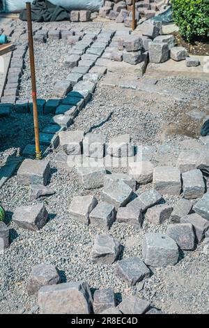 Making path - paving stones, installing and laying pavement stones on terrace, road or sidewalk. Stock Photo