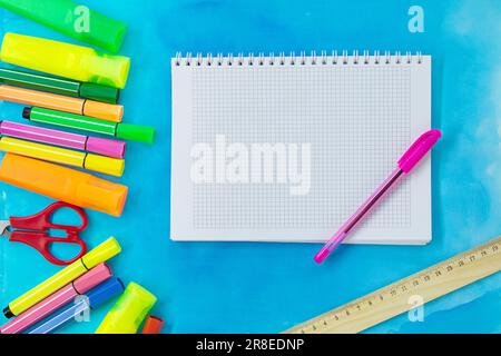 Felt tip pens, scissors, ruler and notepad for drawing or writing. Stationery on abstract blue background. Concept of back to school, education. Copy Stock Photo