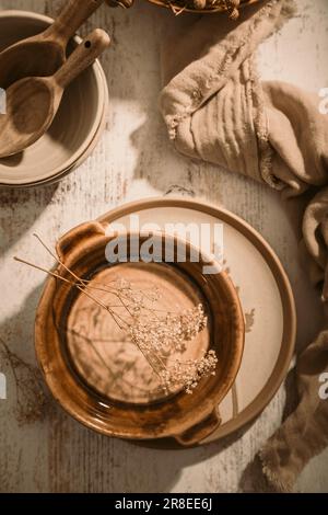 Set of ceramic tableware. Empty craft ceramic plates, bowls and cups kitchen table Stock Photo