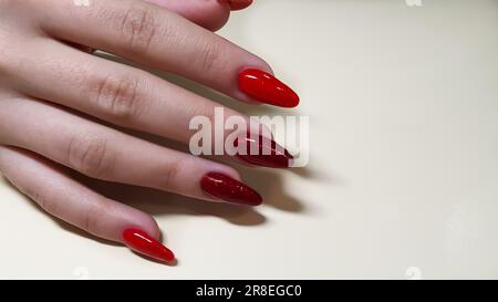 Manicure and nail extension with acrylic and gel. The design was made with  red gel polishes in a beauty salon. copy space Stock Photo - Alamy