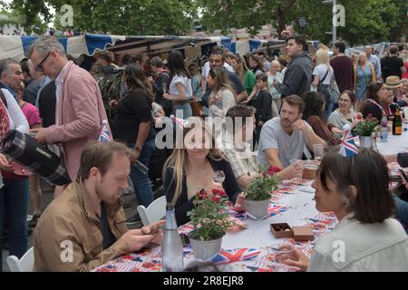 Chelsea, London, England 4th June 2022. The Kings Road, Platinum Jubilee Street Party, that is supporting the British Red Cross Ukraine crisis appeal. The Kings Road is in part closed to traffic, tables run down the centre of the road, food stalls are set up and doing good business. Local Chelsea and Knightsbridge young adults, chat and drink Champagne. Stock Photo