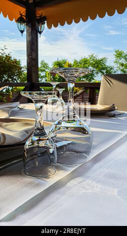 Table setting in the gazebo for the holiday. Glasses and plates on the surface. copy space Stock Photo