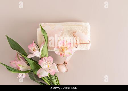 Top view of rose quartz cosmetic roller, gouache scraper on terry towel. Home care for the skin of the face and neck. anti-stress. A copy space Stock Photo