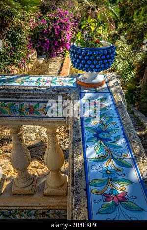 Carved handrail with ceramic pattern and surmounted by a blue basin with a cactus in the city Santo Stefano di Camastra Stock Photo