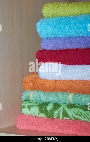 a set of towels are arranged in a closet on a shelf Stock Photo
