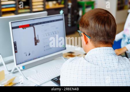 male man sitting at his desk, checking Internet, website, catalog. Architect, interior designer at work, office worker. back view Stock Photo