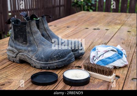 Black pair of leather work boots ready to be clean and wax. Stock Photo