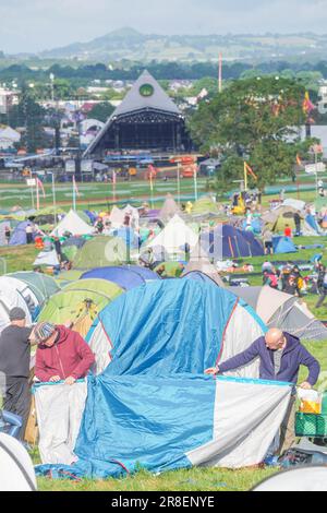 First arrivals pitching their tent at the 2023 Glastonbury festival with the Pyramid stage in the background. Wednesday, 21 June, 2023. Photo: Richard Gray/Alamy Live News Stock Photo