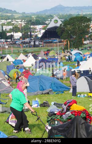 First arrivals pitching their tent at the 2023 Glastonbury festival with the Pyramid stage in the background. Wednesday, 21 June, 2023. Photo: Richard Gray/Alamy Live News Stock Photo