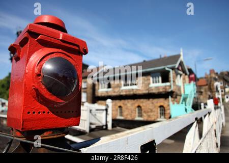 Warning light on level crossing gates at Grosmont station, North Yorkshire Moors Railway, UK. Stock Photo