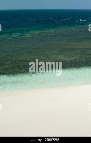 Cristal ocean waves breaking on white sand beach with turquoise emerald water - stock photo Stock Photo