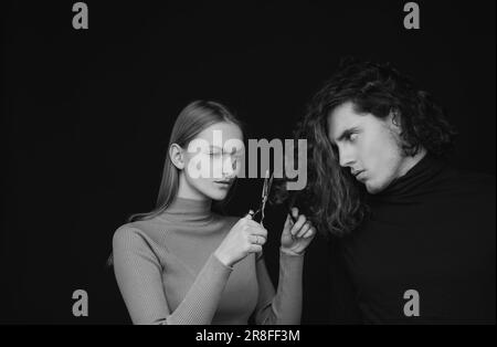 Family crisis. Girl scheming an evil plan of cutting off a curly hair in a man. A smart wily woman has wonderful schemes like a crook of a friend, a Stock Photo