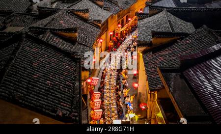 (230621) -- NINGGUO, June 21, 2023 (Xinhua) -- This aerial photo taken on June 16, 2023 shows a lantern performance by the long-table banquet in Hule Town of Ningguo City, east China's Anhui Province. Hule Town, an ancient town in east China's Anhui Province, has a tradition of lantern performance to celebrate festivals.   As the Dragon Boat Festival approaches, villagers perform lantern dance with lanterns in the shape of fish and dragon, and place lotus-shaped water lanterns in the river.    A series of activities including the long-table banquet and the lantern fair have been held to attrac Stock Photo