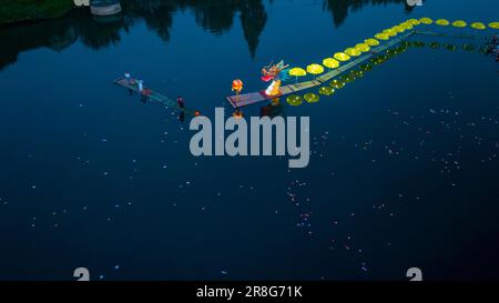 (230621) -- NINGGUO, June 21, 2023 (Xinhua) -- This aerial photo taken on June 16, 2023 shows a lantern performance in Hule Town of Ningguo City, east China's Anhui Province. Hule Town, an ancient town in east China's Anhui Province, has a tradition of lantern performance to celebrate festivals.   As the Dragon Boat Festival approaches, villagers perform lantern dance with lanterns in the shape of fish and dragon, and place lotus-shaped water lanterns in the river.    A series of activities including the long-table banquet and the lantern fair have been held to attract tourists from home and a Stock Photo