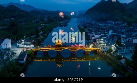 (230621) -- NINGGUO, June 21, 2023 (Xinhua) -- This aerial photo taken on June 16, 2023 shows a lantern performance in Hule Town of Ningguo City, east China's Anhui Province. Hule Town, an ancient town in east China's Anhui Province, has a tradition of lantern performance to celebrate festivals.   As the Dragon Boat Festival approaches, villagers perform lantern dance with lanterns in the shape of fish and dragon, and place lotus-shaped water lanterns in the river.    A series of activities including the long-table banquet and the lantern fair have been held to attract tourists from home and a Stock Photo