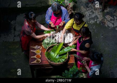 (230621) -- NINGGUO, June 21, 2023 (Xinhua) -- Villagers make Zongzi, a pyramid-shaped glutinous rice dumpling wrapped in bamboo or reed leaves, as the Dragon Boat Festival approaches in Hule Town of Ningguo City, east China's Anhui Province, June 17, 2023. Hule Town, an ancient town in east China's Anhui Province, has a tradition of lantern performance to celebrate festivals.   As the Dragon Boat Festival approaches, villagers perform lantern dance with lanterns in the shape of fish and dragon, and place lotus-shaped water lanterns in the river.    A series of activities including the long-ta Stock Photo