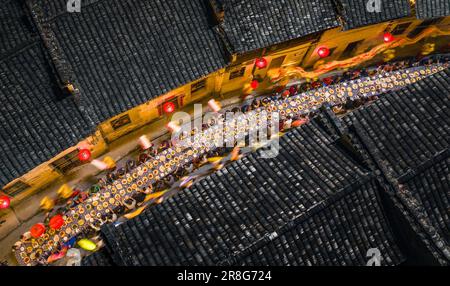 (230621) -- NINGGUO, June 21, 2023 (Xinhua) -- This aerial photo taken on June 16, 2023 shows a lantern performance by the long-table banquet in Hule Town of Ningguo City, east China's Anhui Province. Hule Town, an ancient town in east China's Anhui Province, has a tradition of lantern performance to celebrate festivals.   As the Dragon Boat Festival approaches, villagers perform lantern dance with lanterns in the shape of fish and dragon, and place lotus-shaped water lanterns in the river.    A series of activities including the long-table banquet and the lantern fair have been held to attrac Stock Photo
