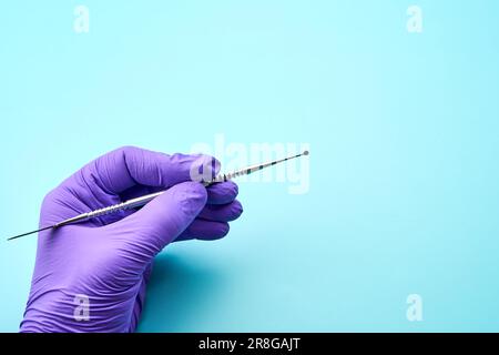Dental technician holds a working tool on a green table Stock Photo