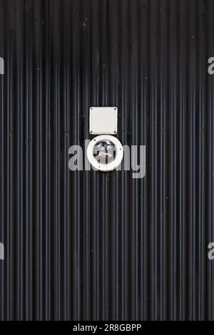 Surveillance cameras placed on a corrugated black metal wall Stock Photo