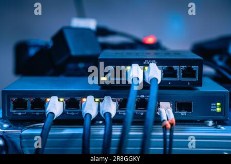 Several ethernet cables linked to a network router for establishing an internet connection Stock Photo