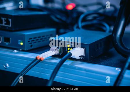 Several ethernet cables linked to a network router for establishing an internet connection Stock Photo