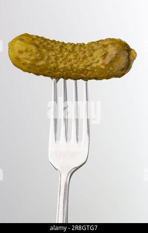 Pickled gherkin on fork Stock Photo