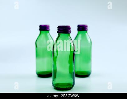 Set of green Glass bottles with purple cap. Isolated on white background. Stock Photo