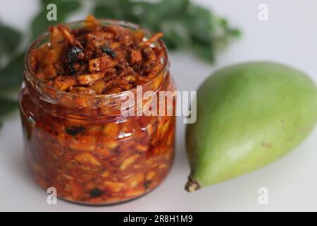 Kadumanga achar. Kerala style instant mango pickle made of chopped unripe raw totapuri mangoes, with mustard leaves, curry leaves and spices. It is a Stock Photo