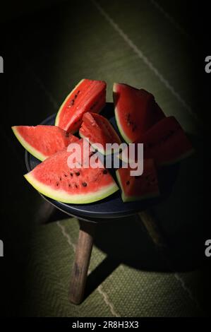Sliced watermelon on a plate and old chair with natural light Stock Photo