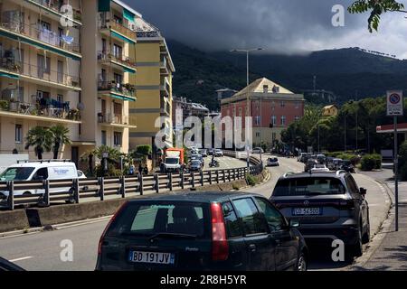 Highway  with parked cars by its edge and buildings next to it on a cloudy day in an italian city Stock Photo
