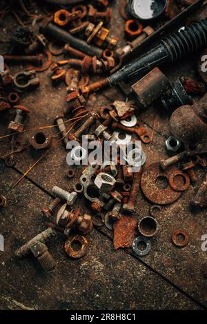 A variety of rusty screws, bolts, and tools scattered on a floor, abandoned and forgotten Stock Photo