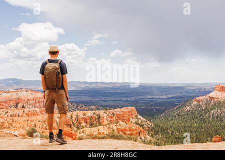 Hiker standing with a view to Bryce canyon, Utah, looking on the rock formations, view from the back. Stock Photo