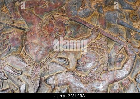 Ancient art captured on stone: Battle scenes from Hindu mythology etched on the walls of an ancient Khmer temple, standing as a testament of time. Stock Photo