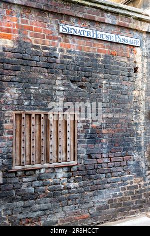 An old wooden shuttered window on the wall of Gonville and Caius College, University of Cambridge, on Sentate House Passage. Stock Photo