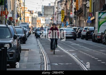 Brussels streets buzz with lively energy as people stroll along, savoring the atmosphere. Charming street bars dot the sidewalks and street bars Stock Photo