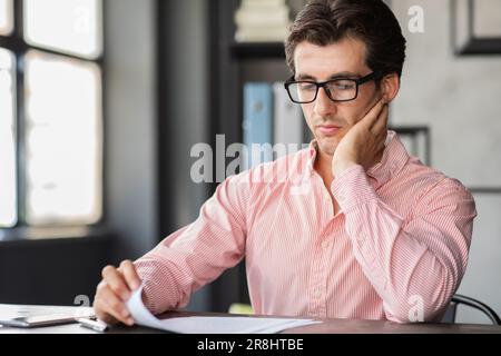 Busy corporate young man working with papers at office Stock Photo