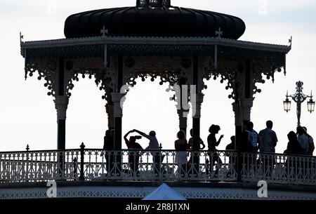 Brighton UK 21st June 2023 - Dancers enjoy a summer solstice salsa on Brighton bandstand tonight as the sun starts to go down on the longest day of the year : Credit Simon Dack / Alamy Live News Stock Photo