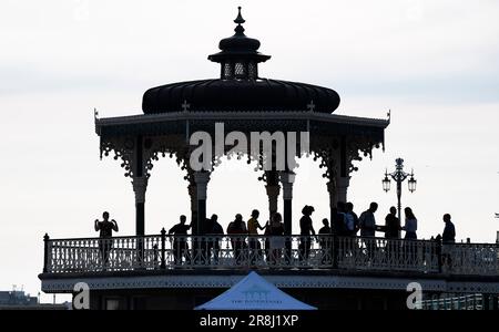 Brighton UK 21st June 2023 - Dancers enjoy a summer solstice salsa on Brighton bandstand tonight as the sun starts to go down on the longest day of the year : Credit Simon Dack / Alamy Live News Stock Photo