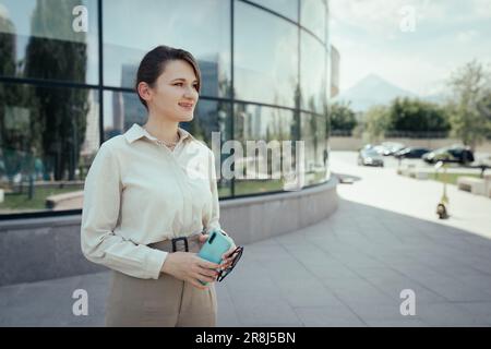 Woman outdoor portrait in business office style with phone in hand in the city streets Stock Photo