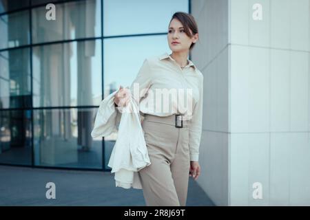 Outdoor shot of caucasian business woman, going somewhere in city centre, walking on street, going to work Stock Photo