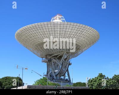 A row of Robledo de Chavela radio telescope antennas are pictured in the foreground against a clear blue sky in the background Stock Photo
