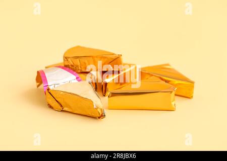 Triangles of tasty processed cheese on yellow background Stock Photo