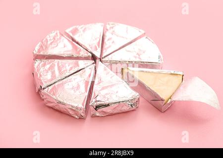 Triangles of tasty processed cheese on pink background Stock Photo