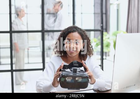 woman testing VR glasses or goggles sitting in the office room Stock Photo