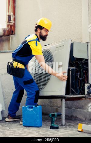 Skilled wireman starting work on malfunctioning air conditioner, using