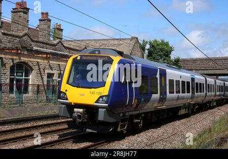 Northern Trains Civity class 195 diesel multiple unit 195125 passing Carnforth on West Coast Main Line with Manchester Airport train, 21st June 2023. Stock Photo