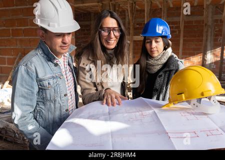 Construction engineer and architects working with the blueprint at the construction site. Teamwork, collaboration and development of a construction si Stock Photo