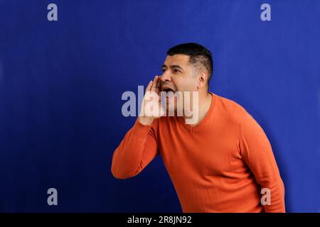 40-year-old latino man screams desperate, frustrated, anguished and distressed Stock Photo