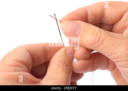 Woman threading sewing needle on white background, closeup Stock Photo